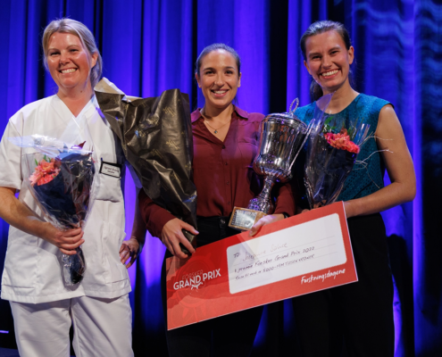 De tre beste kandidatene i Forsker Grand Pirx med blomsterbukett og pokal