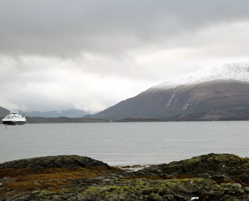 Fjell med tåke rundt som ligger ved en fjord