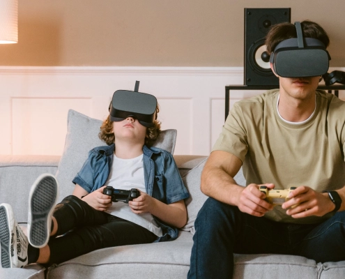 Gutt og en man sitter på sofaen med VRbriller på