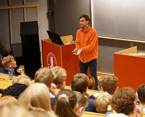 Foredragsholder foran et fullsatt auditorium